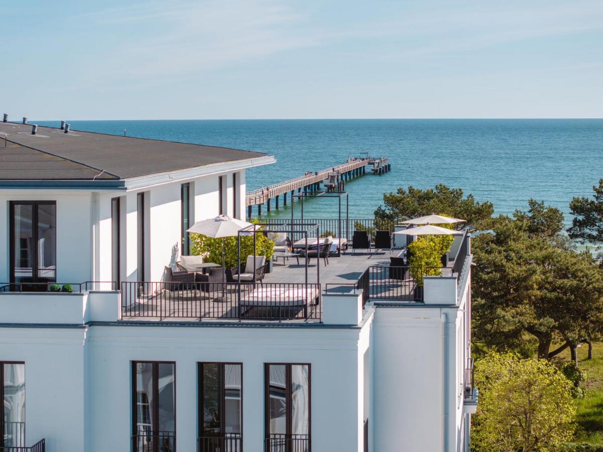 ein weißes Gebäude mit einem Pier direkt am Meer in der Unterkunft A-ROSA Hotel Ceres am Meer - Adults Only in Binz