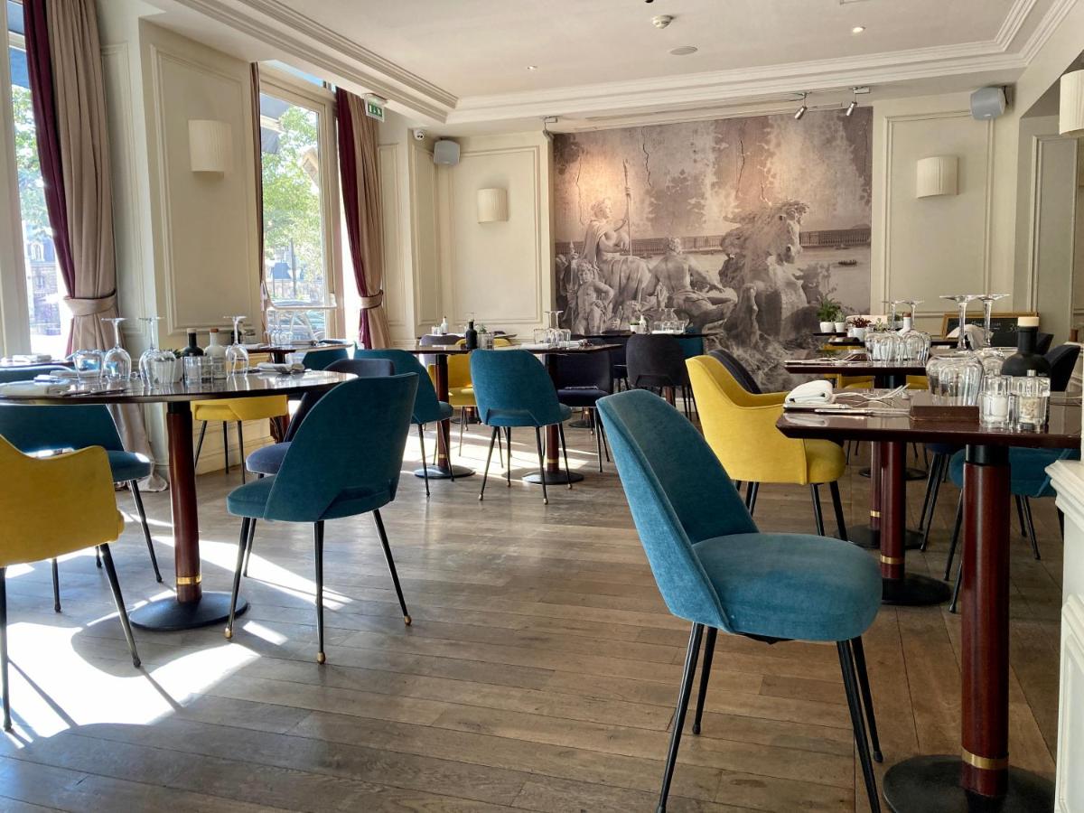un restaurant avec des tables et des chaises et un tableau au mur dans l'établissement Hôtel de Sèze & Spa Bordeaux Centre, à Bordeaux