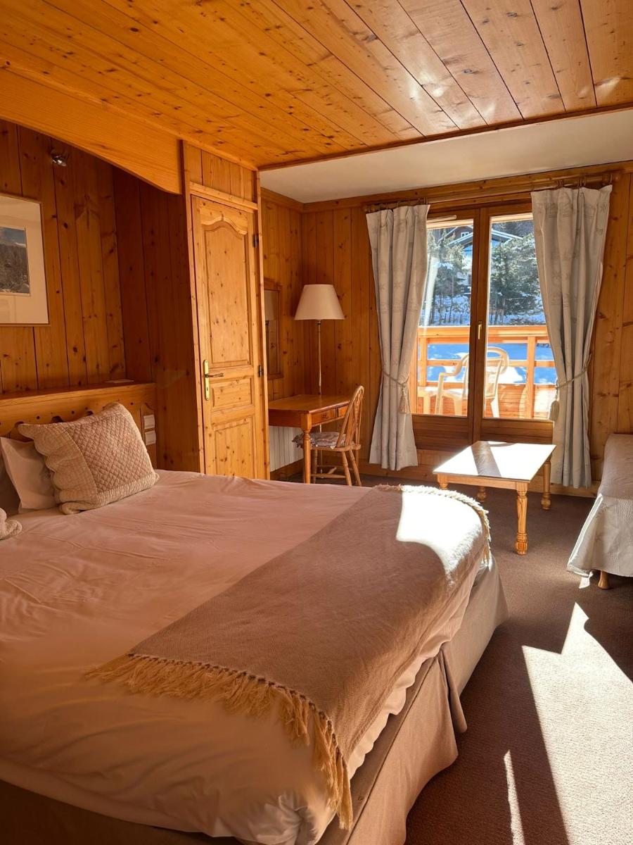 une chambre avec un grand lit dans une pièce avec une table dans l'établissement Hôtel Le Jeu de Paume, à Chamonix-Mont-Blanc 43 autres photos