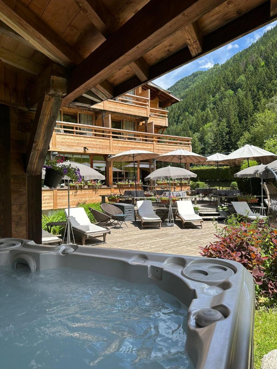 un bain à remous devant un complexe hôtelier avec chaises et parasols dans l'établissement Hôtel Le Jeu de Paume, à Chamonix-Mont-Blanc