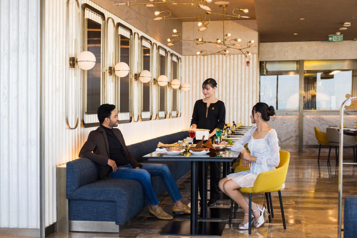 a group of people sitting at a table in a restaurant at The Den, Bengaluru in Bengaluru