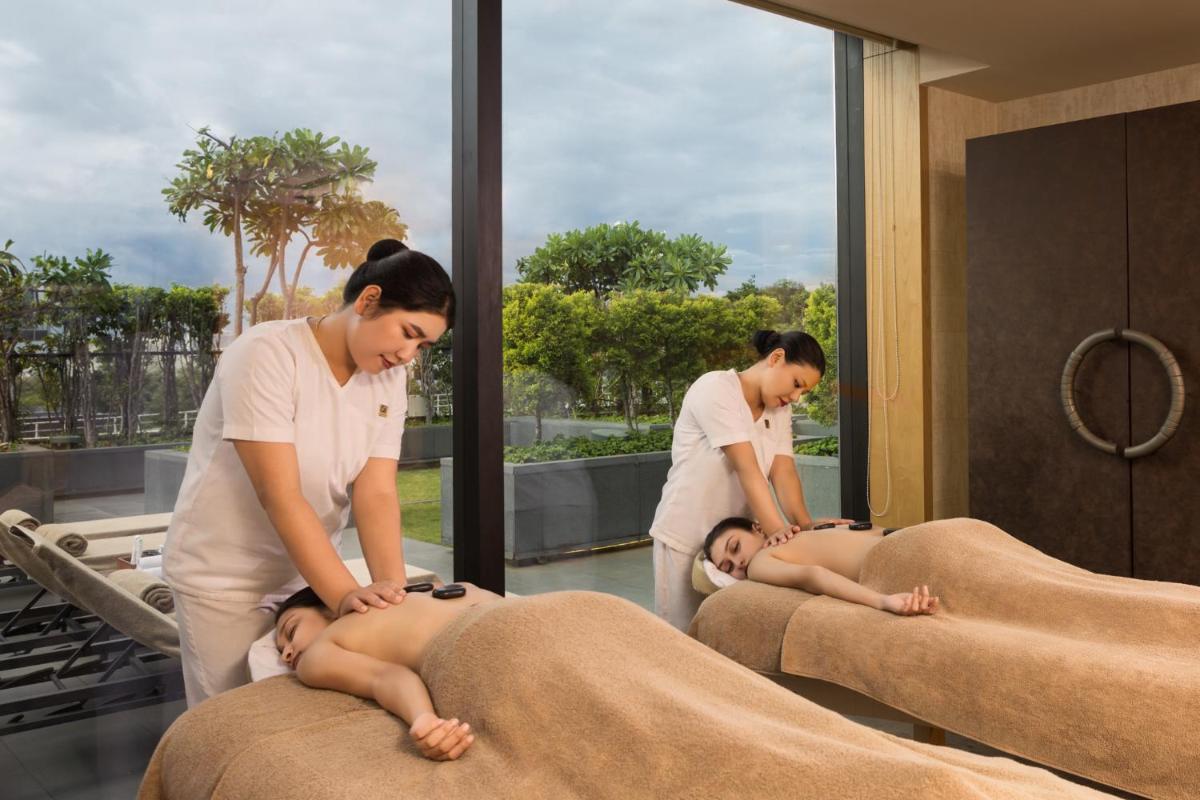 a couple of women are laying on massage beds at The Den, Bengaluru in Bengaluru