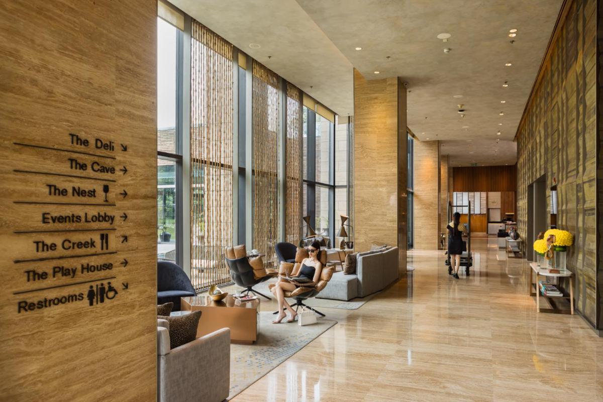 a lobby of a building with people sitting in chairs at The Den, Bengaluru in Bengaluru
