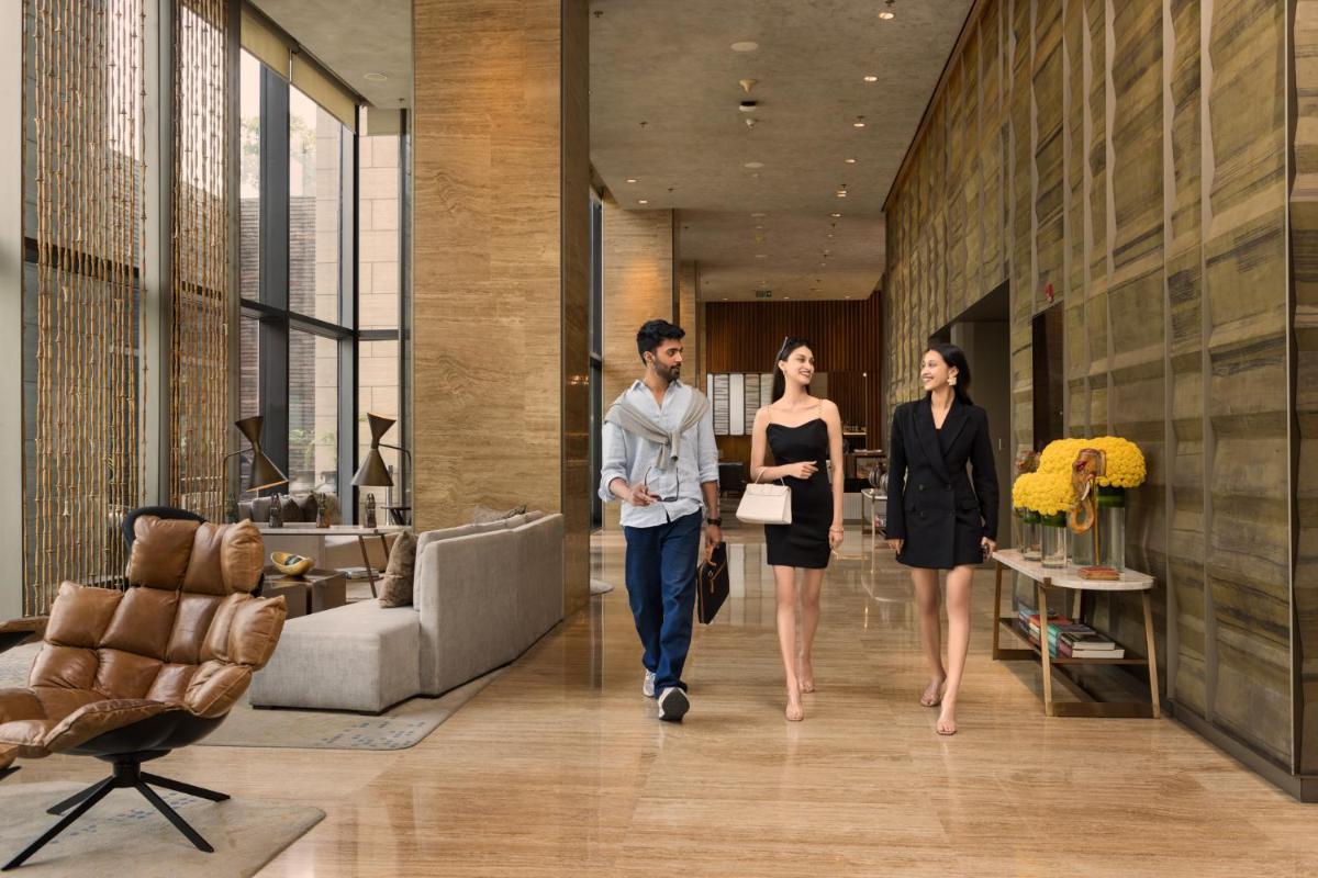 three people walking down a hallway in a lobby at The Den, Bengaluru in Bengaluru