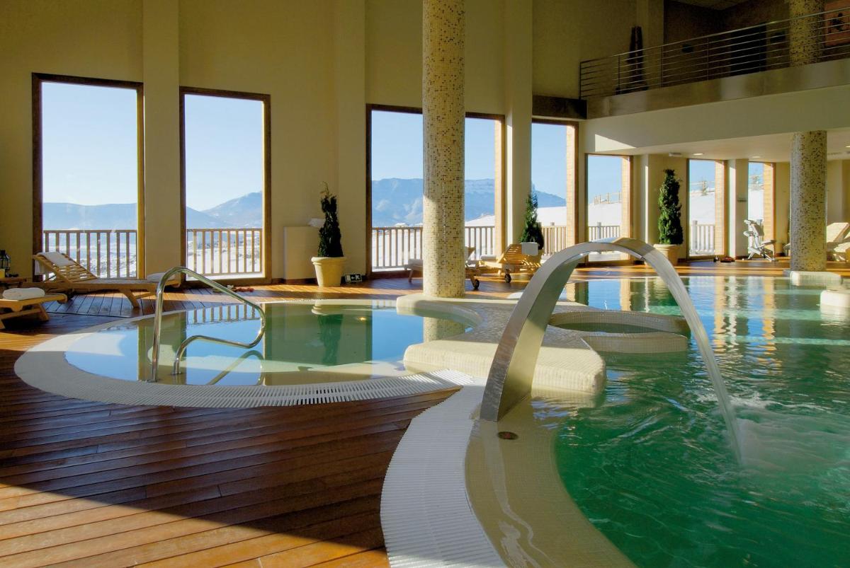 una piscina con 2 toboganes de agua en un edificio en Hotel & Spa Real Badaguás Jaca, en Badaguás