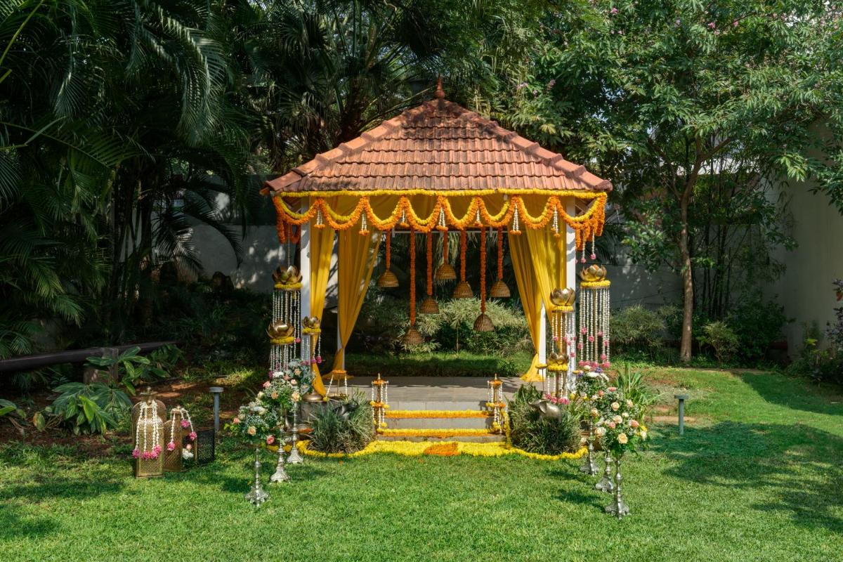 a gazebo in a yard with flowers at Southern Star,Mysore in Mysore