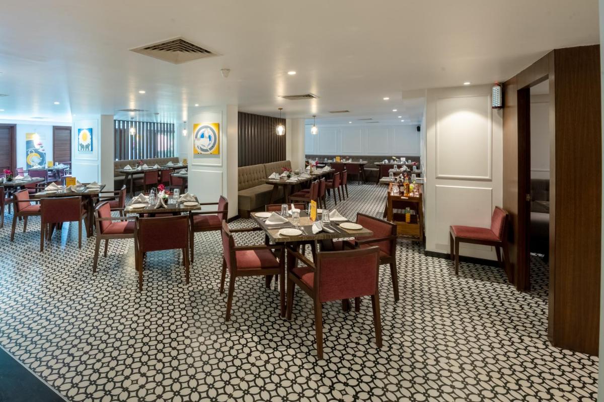 a dining room with tables and chairs and a restaurant at Southern Star,Mysore in Mysore