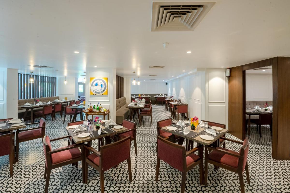 a restaurant with tables and chairs in a room at Southern Star,Mysore in Mysore