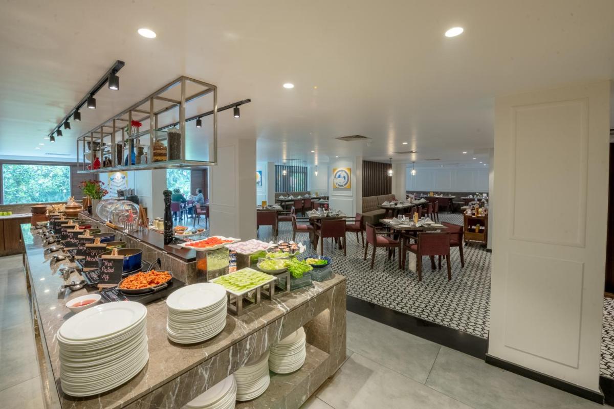 a buffet line in a restaurant with a table of food at Southern Star,Mysore in Mysore