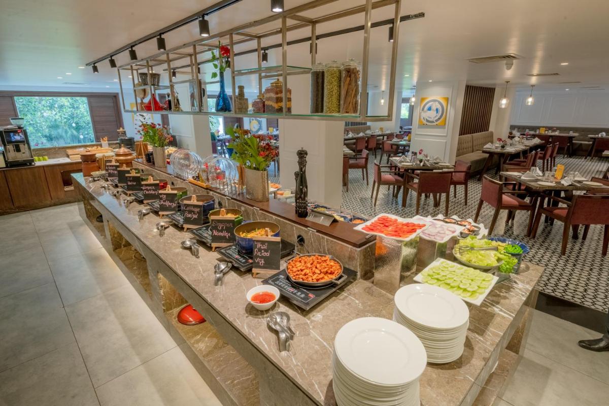a buffet line with food on it in a restaurant at Southern Star,Mysore in Mysore