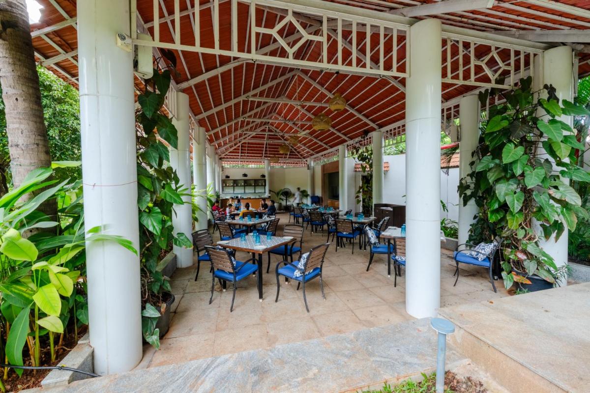 an outdoor patio with tables and chairs and plants at Southern Star,Mysore in Mysore