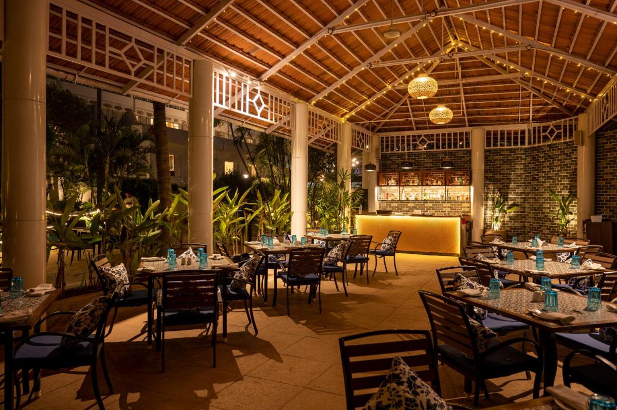 a restaurant with tables and chairs in a building at Southern Star,Mysore in Mysore