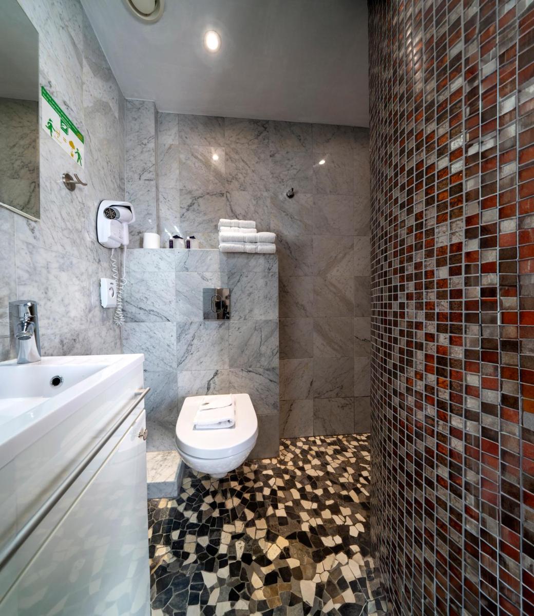 une salle de bain avec toilettes et lavabo dans l'établissement Hôtel du Parc, Restaurant, Spa & Wellness, à Niederbronn-les-Bains