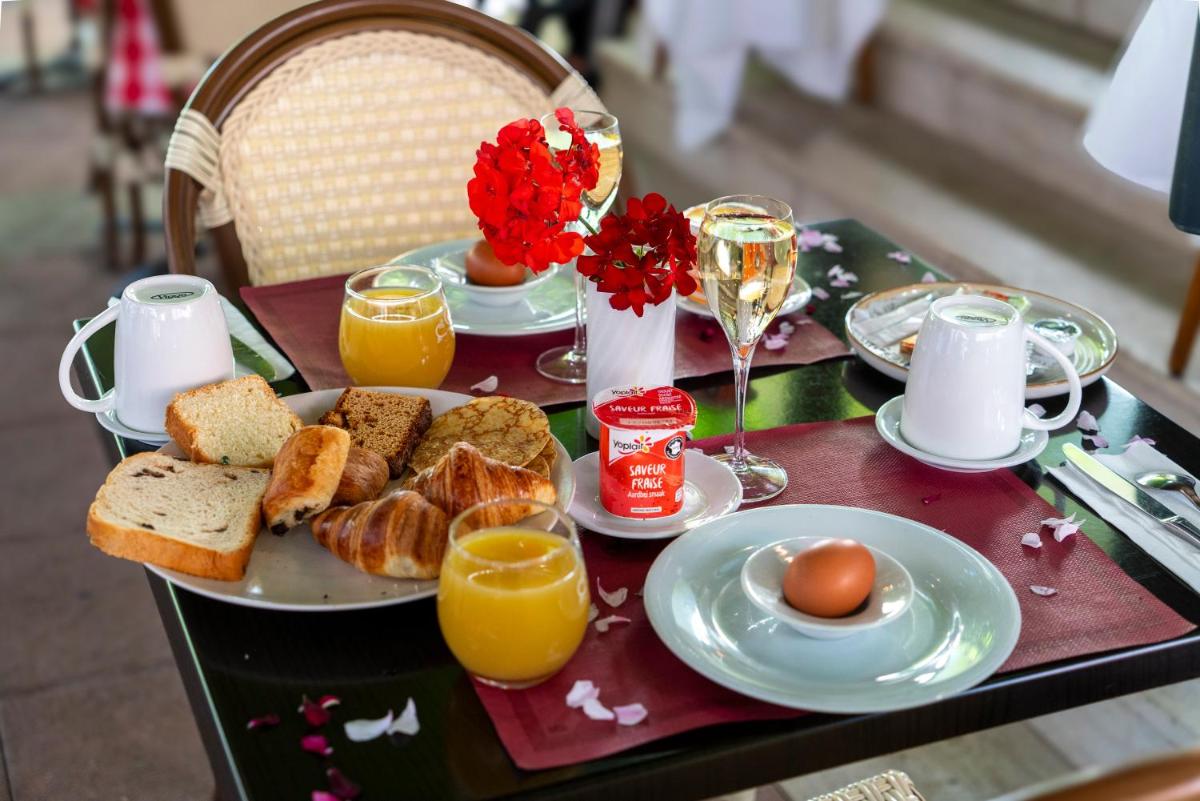 une table de petit-déjeuner avec du pain grillé, des œufs et du jus d'orange dans l'établissement Hôtel du Parc, Restaurant, Spa & Wellness, à Niederbronn-les-Bains