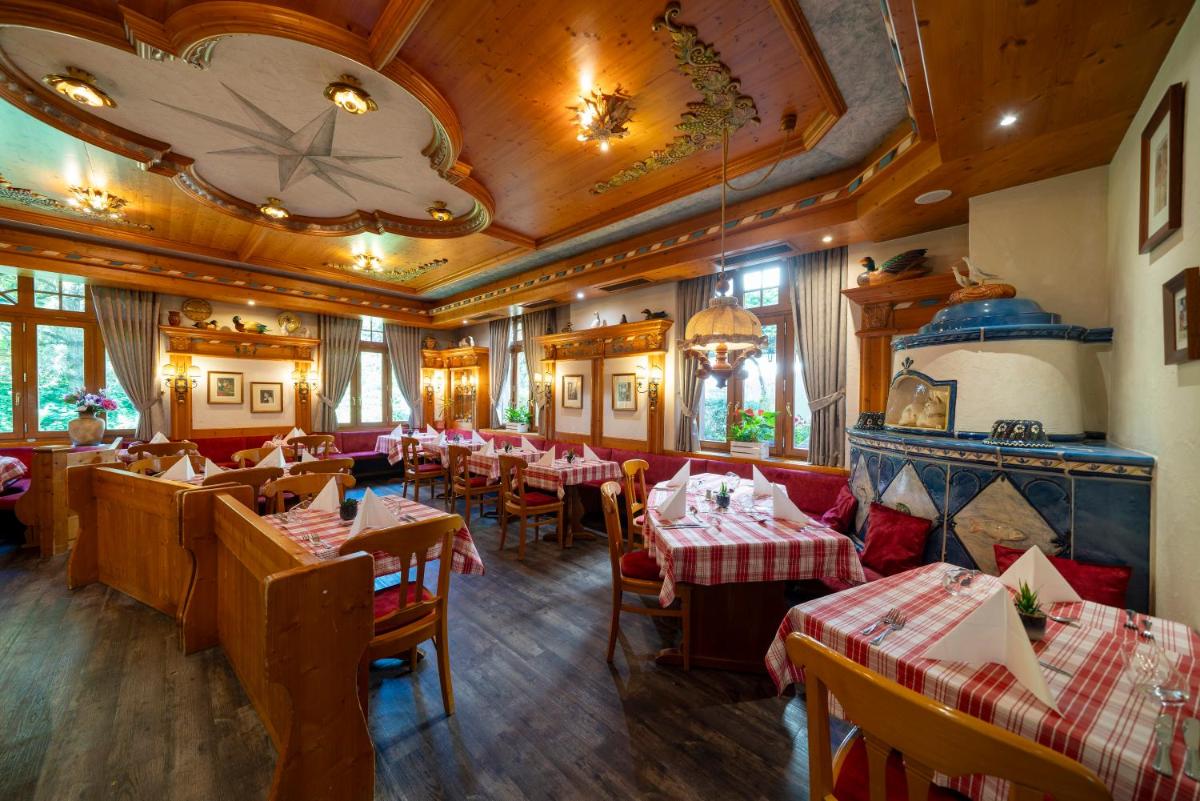 un restaurant avec des tables et des chaises et un plafond dans l'établissement Hôtel du Parc, Restaurant, Spa & Wellness, à Niederbronn-les-Bains