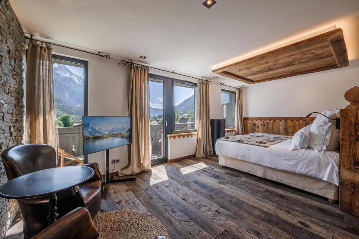 - une chambre avec un lit, un bureau et quelques fenêtres dans l'établissement Chalet-Hôtel Hermitage, à Chamonix-Mont-Blanc