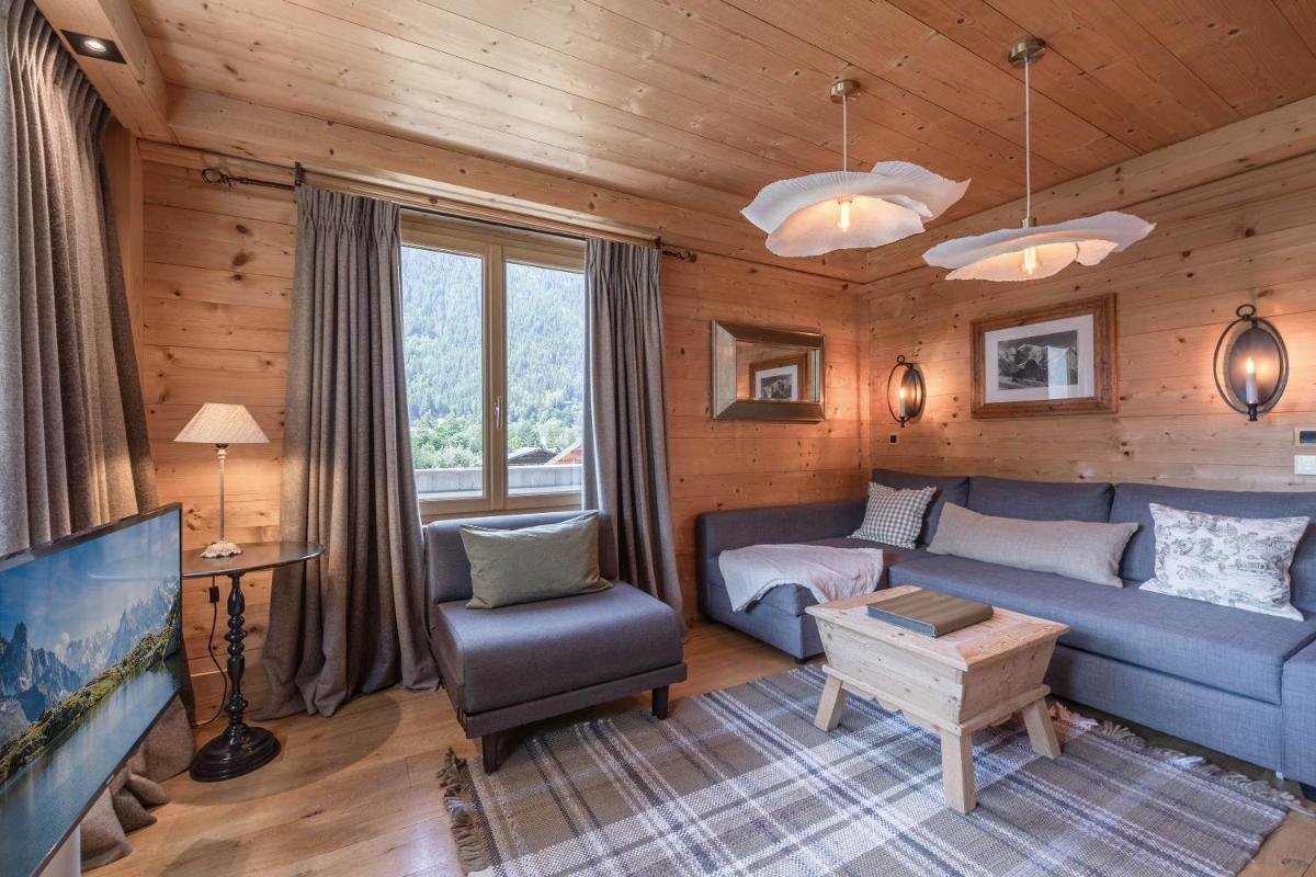 un salon avec un canapé bleu et une télévision dans l'établissement Chalet-Hôtel Hermitage, à Chamonix-Mont-Blanc