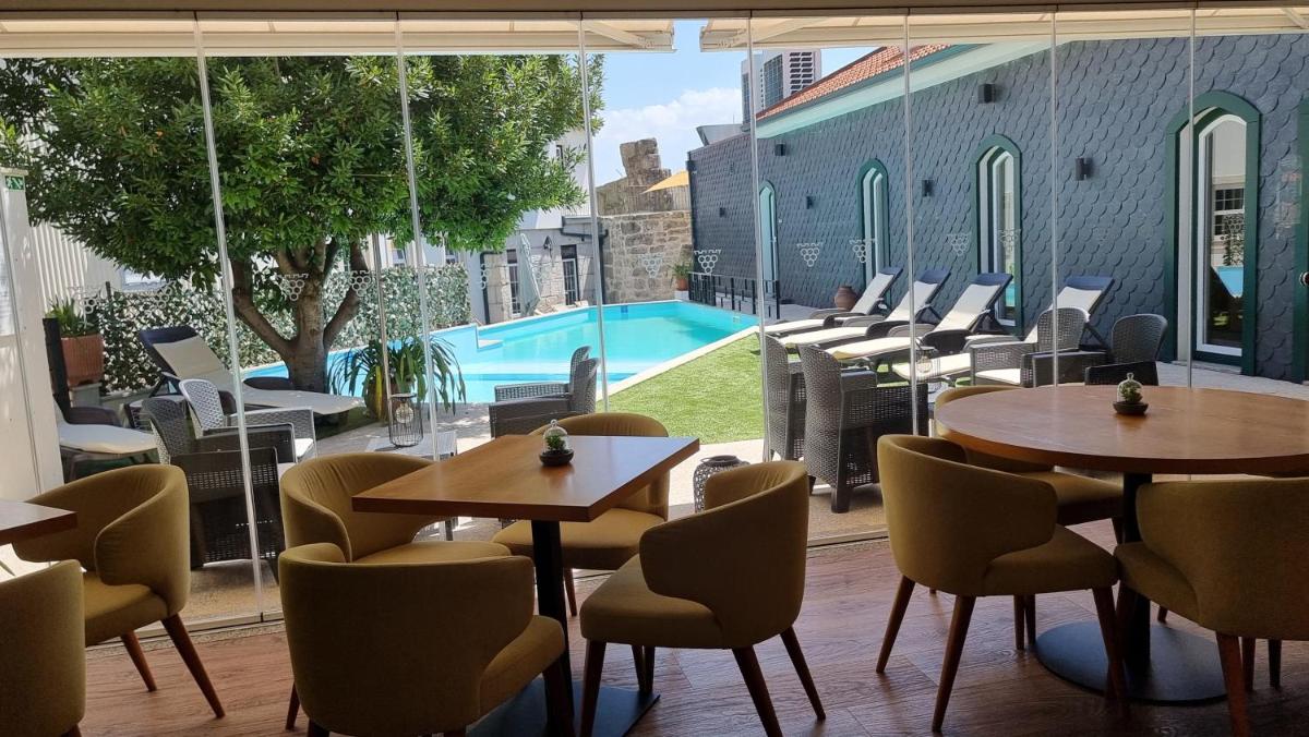 um restaurante com mesas e cadeiras e uma piscina em Douro Castelo Signature Hotel & Spa em Lamego