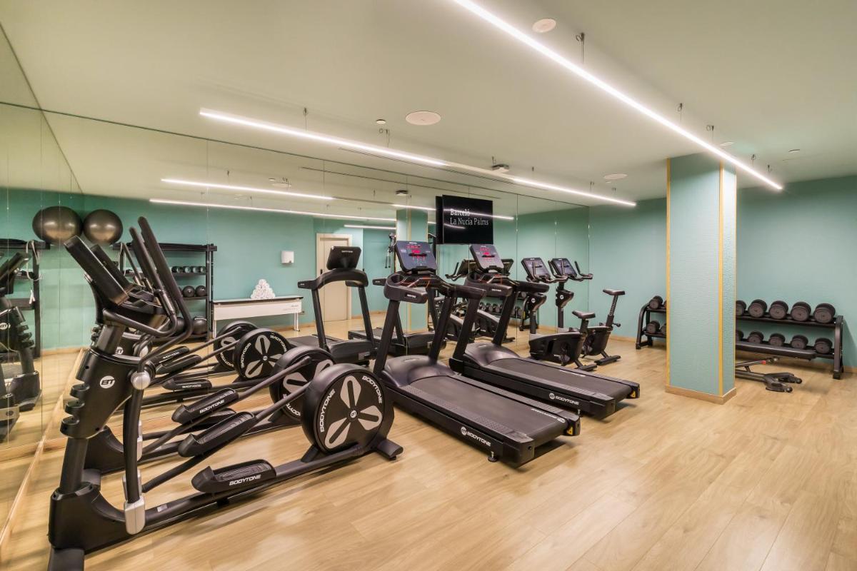 un gimnasio con un montón de cintas de correr y bicicletas estáticas en Barceló La Nucía Palms, en La Nucía
