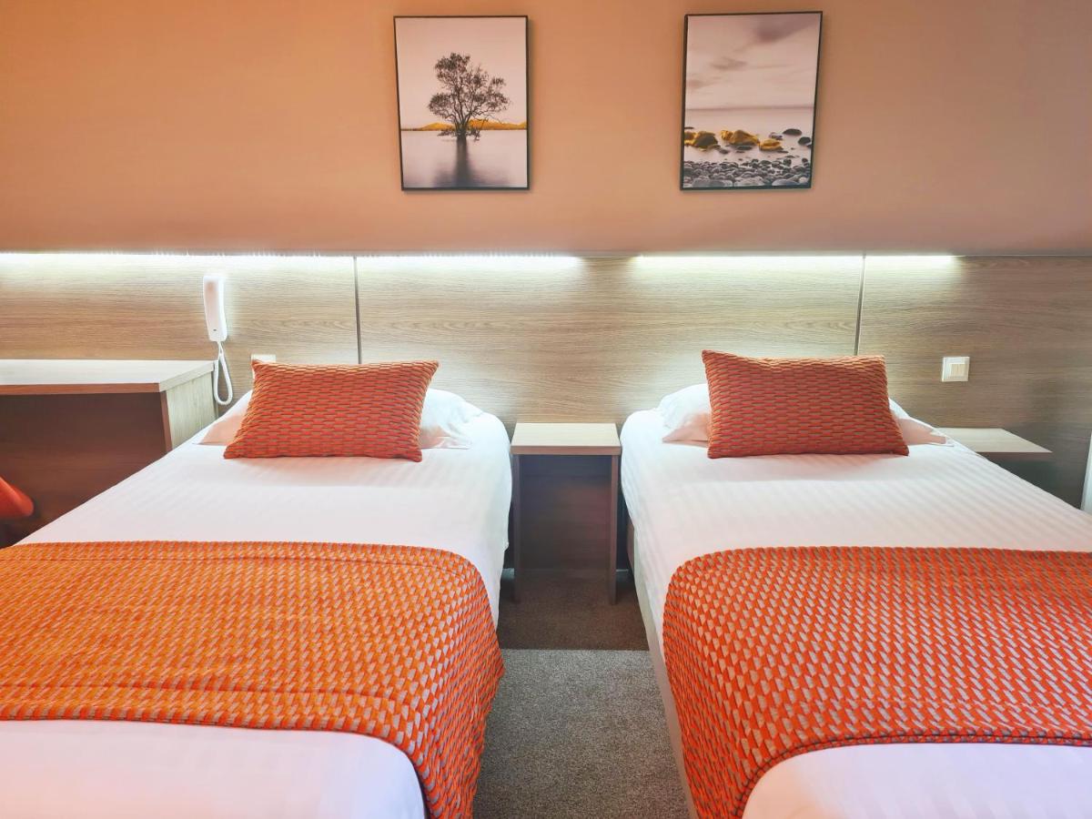Un ou plusieurs lits dans un hébergement de l'établissement Brit Hotel Piscine & Spa - Fougères