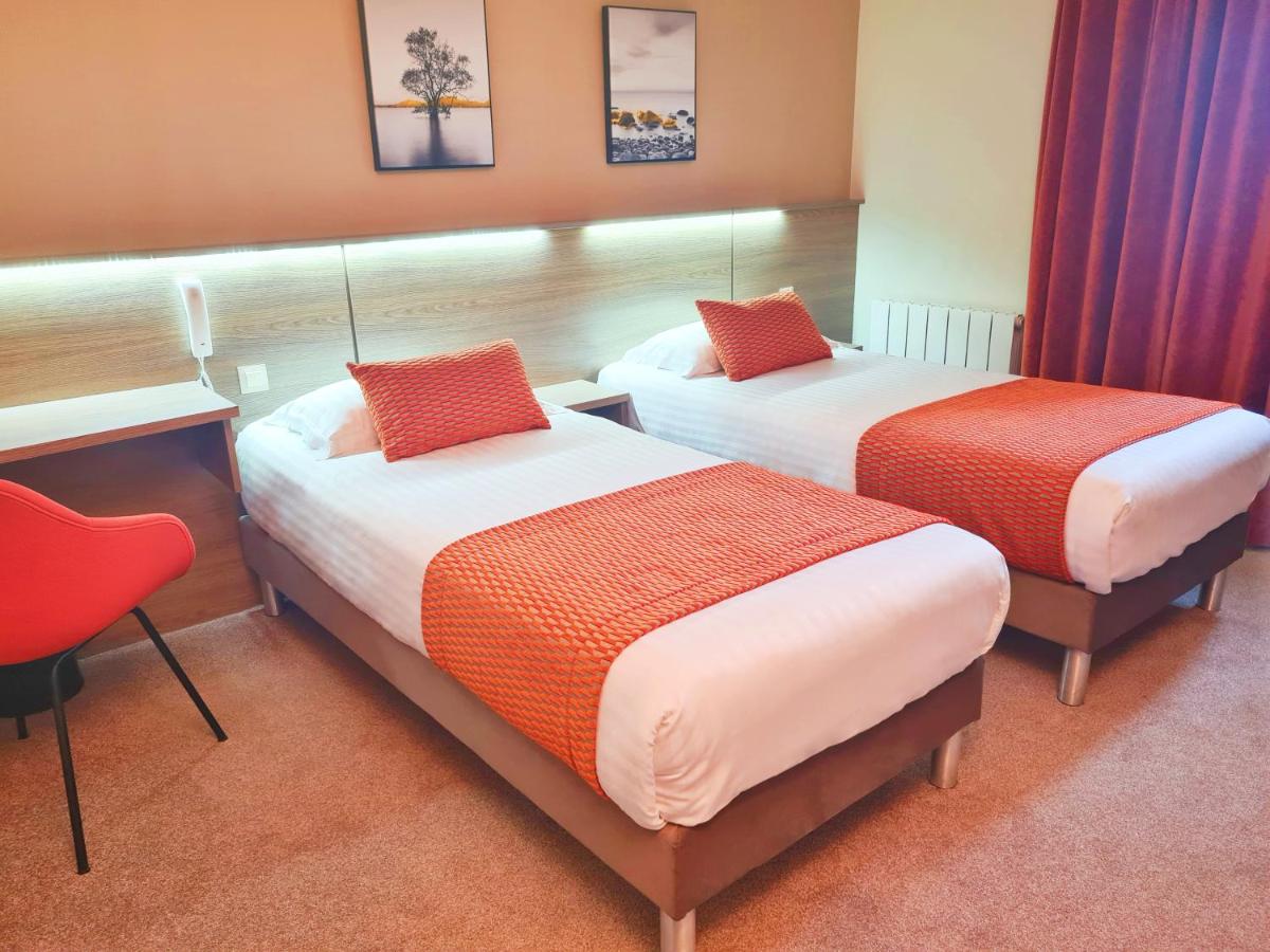 Un ou plusieurs lits dans un hébergement de l'établissement Brit Hotel Piscine & Spa - Fougères