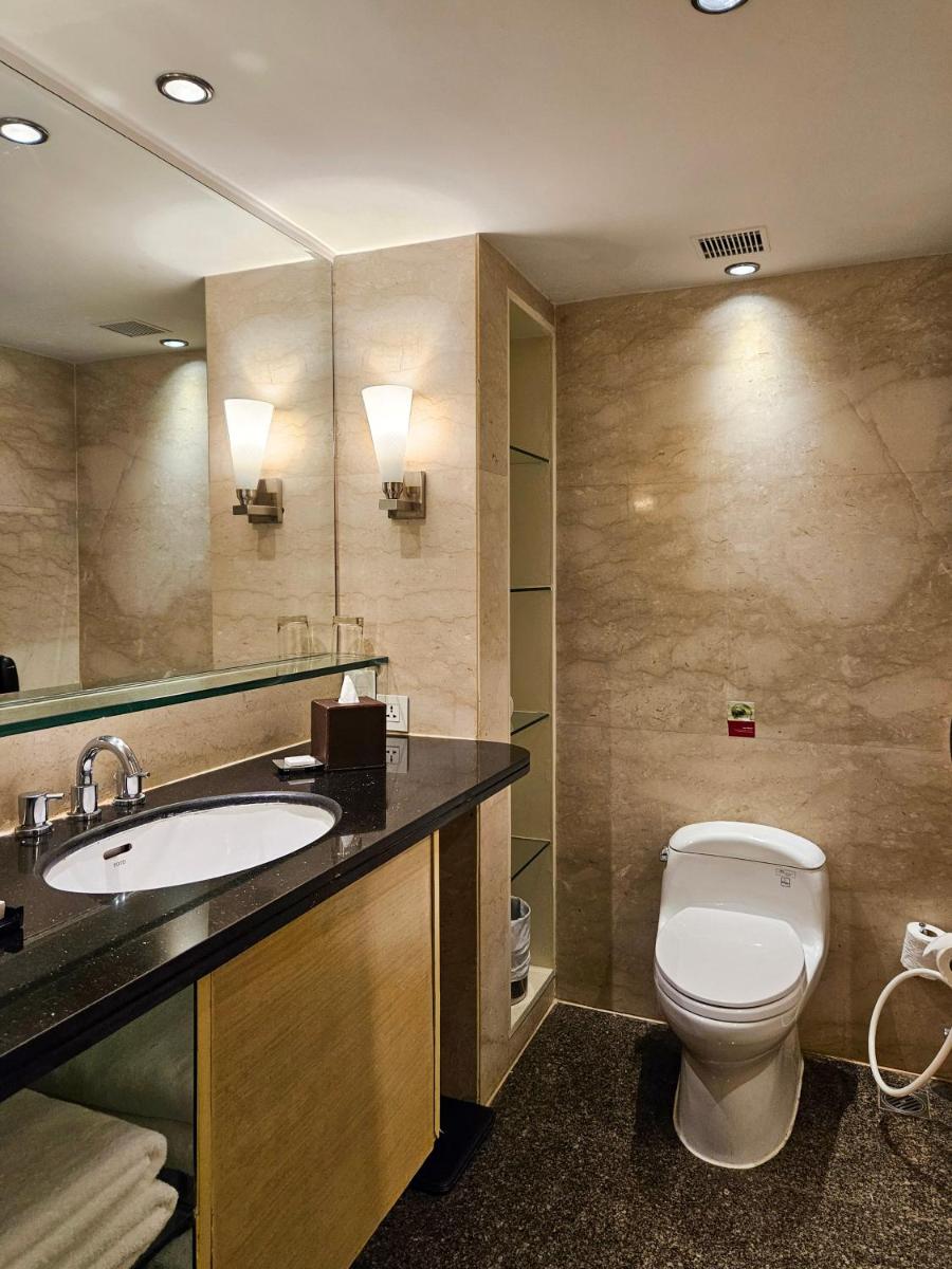 a bathroom with a toilet and a sink at Marriott Executive Apartment - Lakeside Chalet, Mumbai in Mumbai
