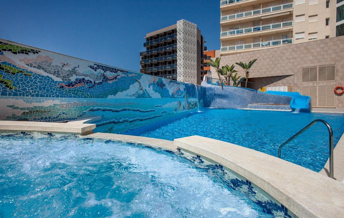 Una piscina con un mural en el costado de un edificio. en Hotel RH Vinaros Playa & Spa 4* Sup, en Vinarós