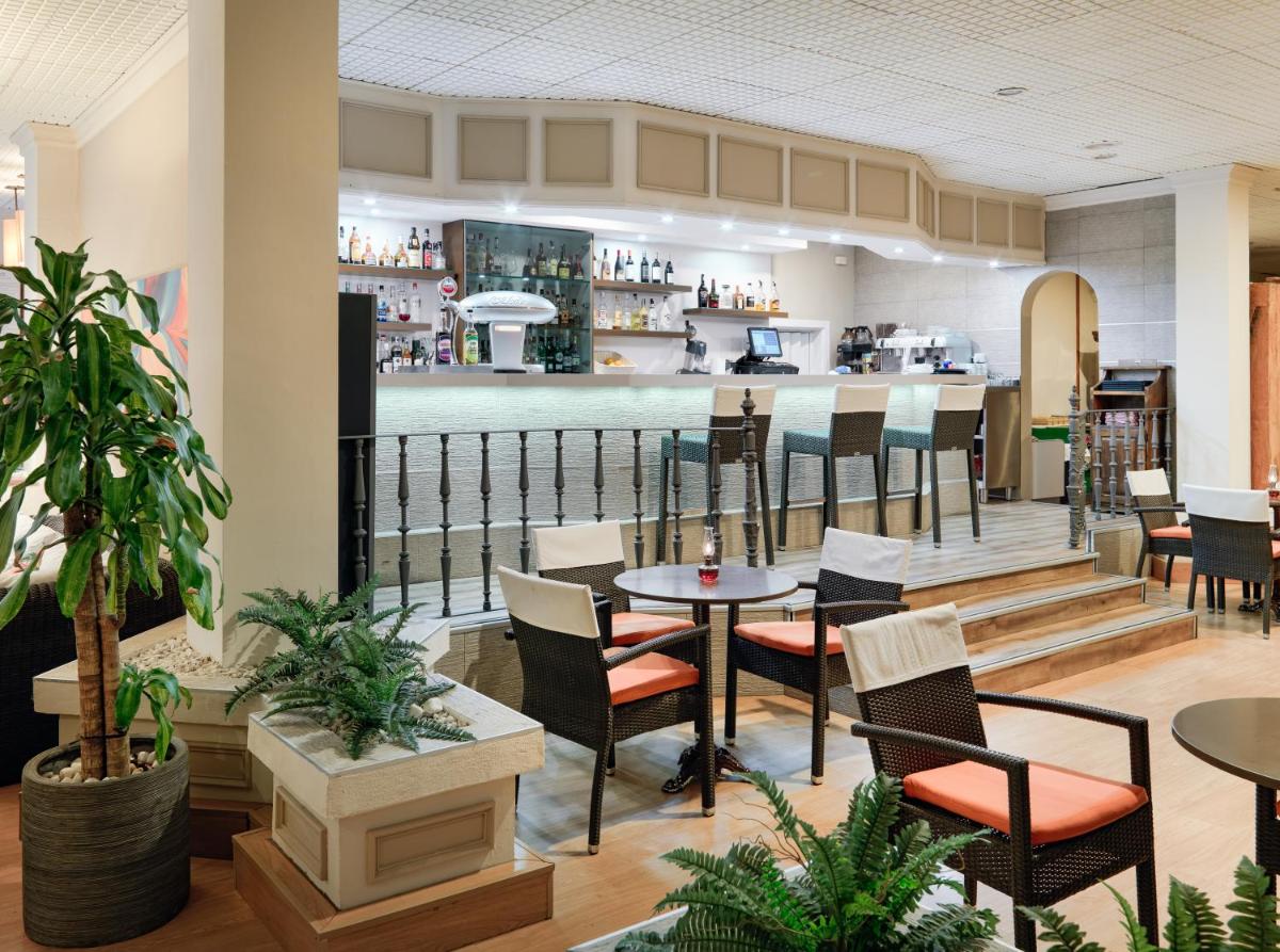 Un restaurante con mesas y sillas y un bar. en Regency Torviscas Apartments and Suites, en Adeje