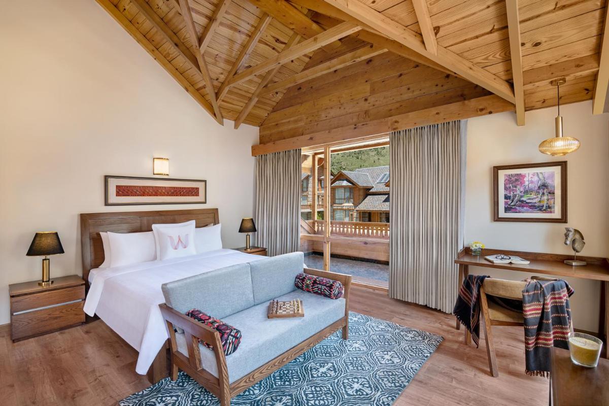 a bedroom with a bed and a couch and a desk at Welcomhotel By ITC Hotels, Hamsa Manali in Manāli a bedroom with a bed and a couch and a desk at Welcomhotel By ITC Hotels, Hamsa Manali in Manāli