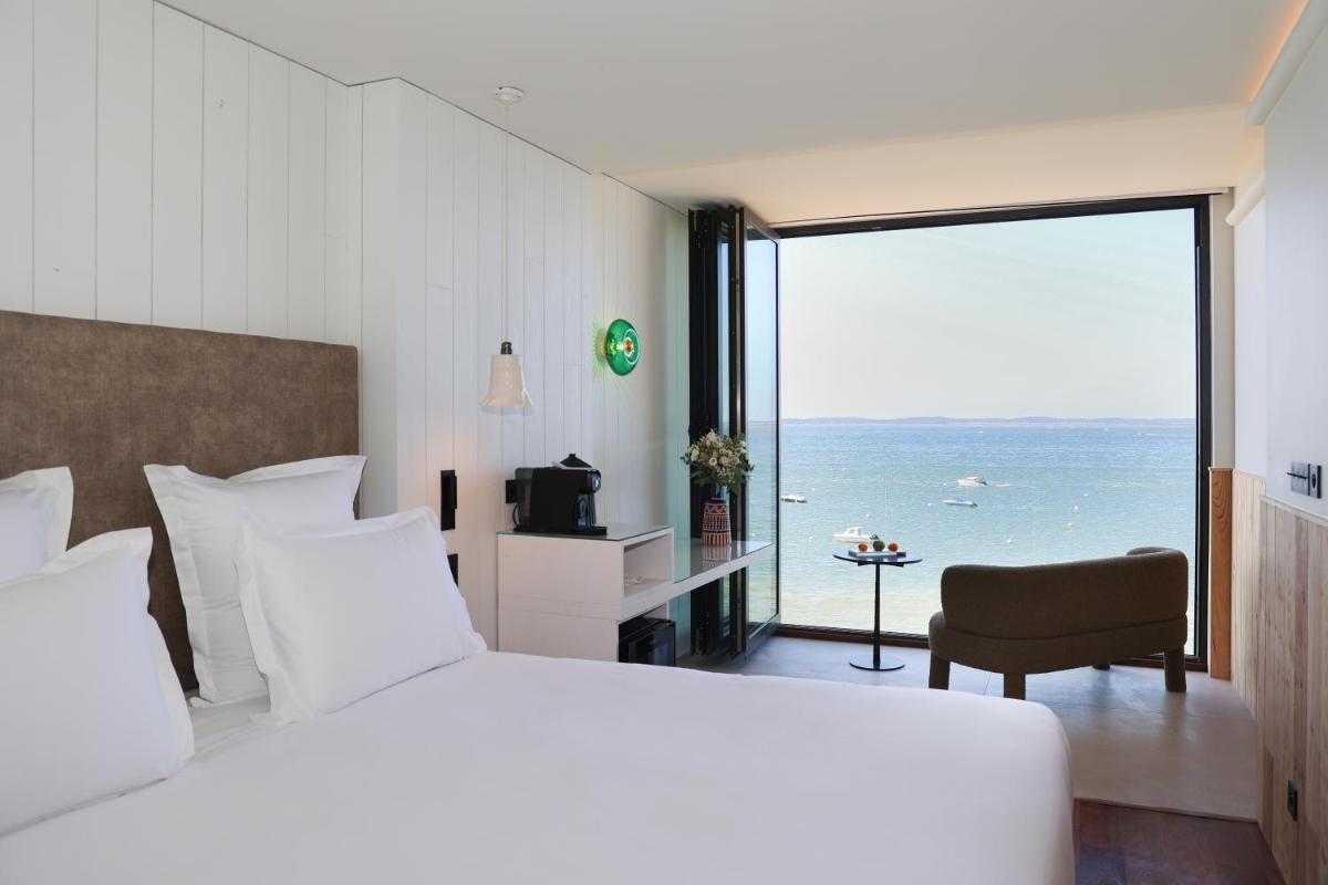 une chambre avec un grand lit avec vue sur l'océan dans l'établissement Les Vagues Hotel & Spa, à Arcachon