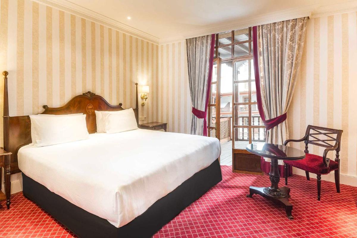 Un dormitorio con una cama, una mesa y una silla. en Eurostars Hotel de la Reconquista, en Oviedo