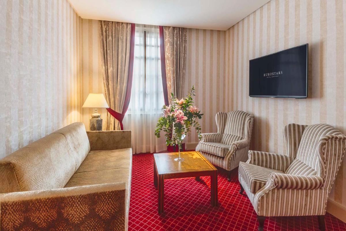 una sala de estar con un sofá y dos sillas en Eurostars Hotel de la Reconquista, en Oviedo