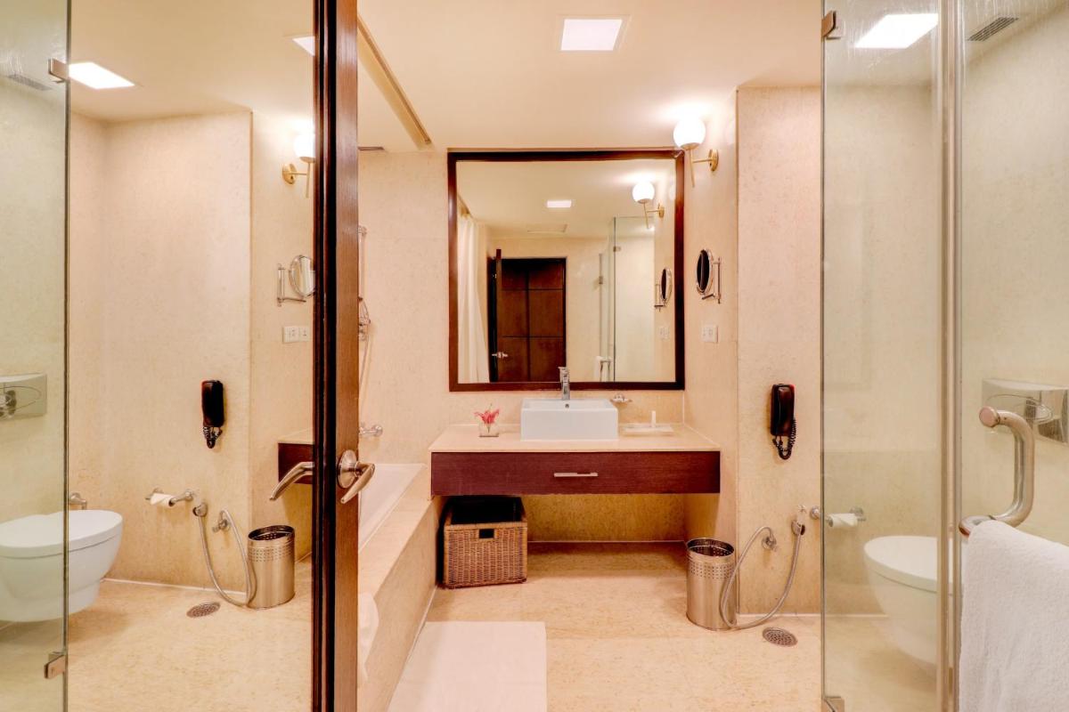a bathroom with a sink and a toilet and a mirror at Sunday Hotel Jaipur in Jaipur