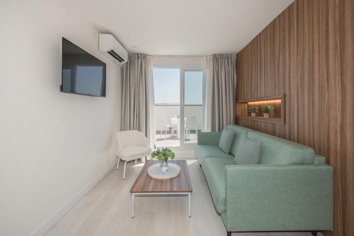 Una sala de estar con un sofá verde y una mesa. en Eurosalou & Spa, en Salou
