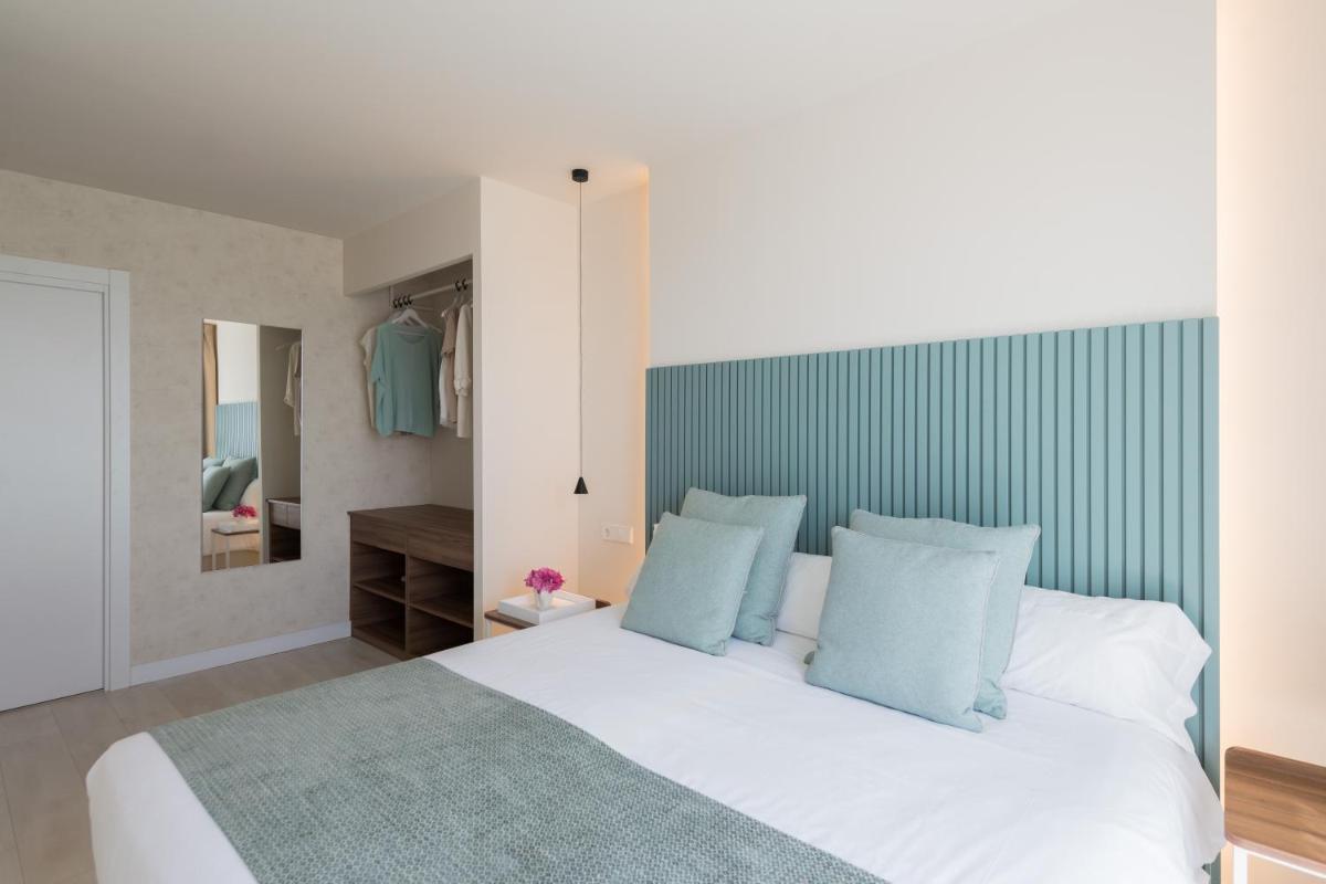 Un dormitorio con una gran cama blanca con almohadas azules. en Eurosalou & Spa, en Salou