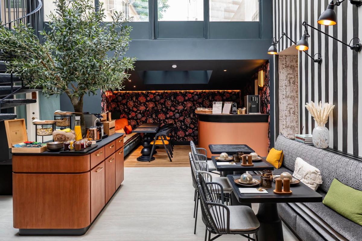 un restaurant avec des tables, des chaises et un comptoir dans l'établissement Hôtel Hiro Paris, à Paris