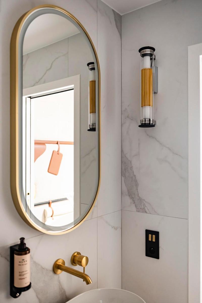 une salle de bain avec un lavabo et un miroir dans l'établissement Hôtel Hiro Paris, à Paris