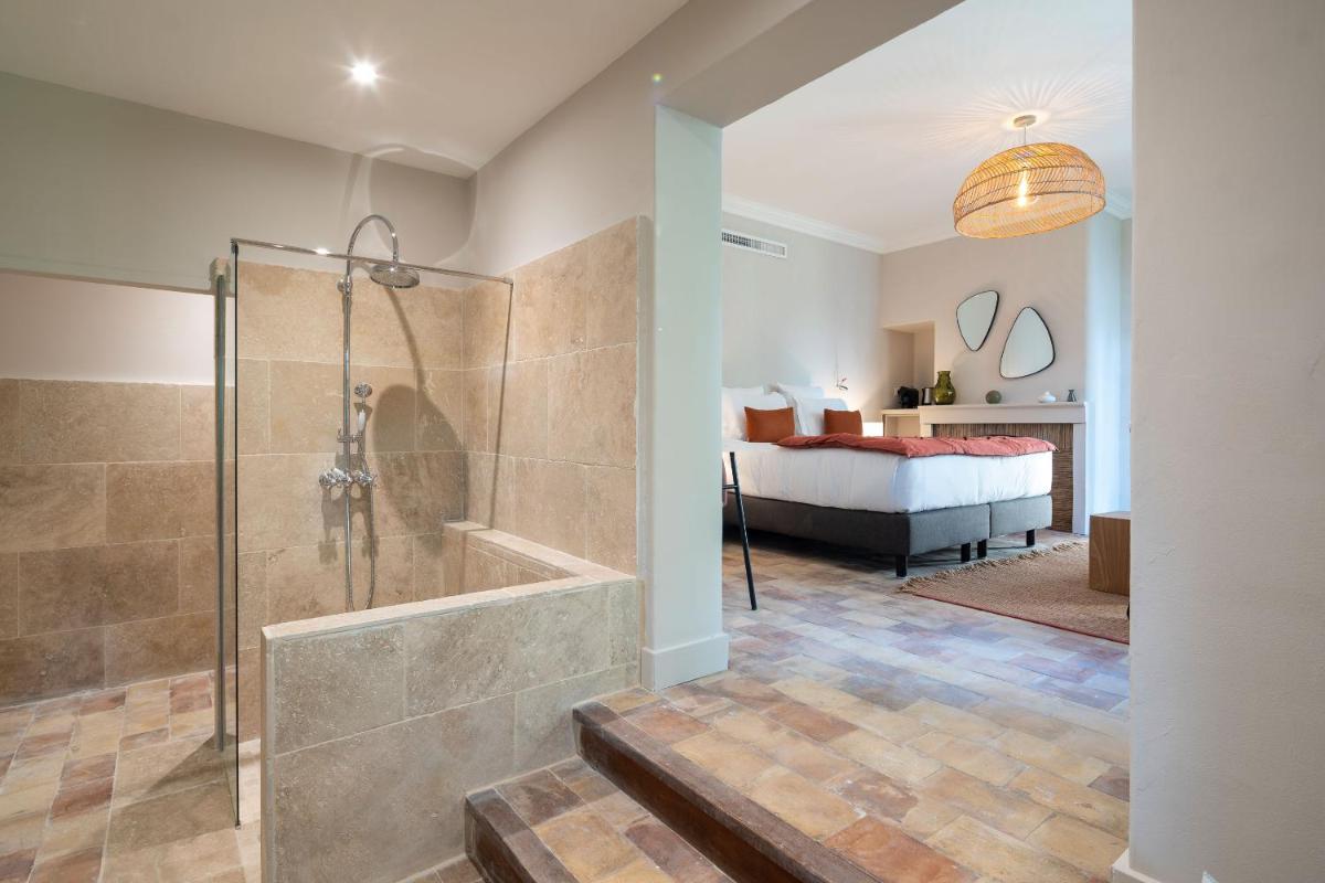 une salle de bains avec douche et une chambre dans l'établissement Hôtel - Restaurant & Spa La Magdeleine - Mathias Dandine, à Gémenos
