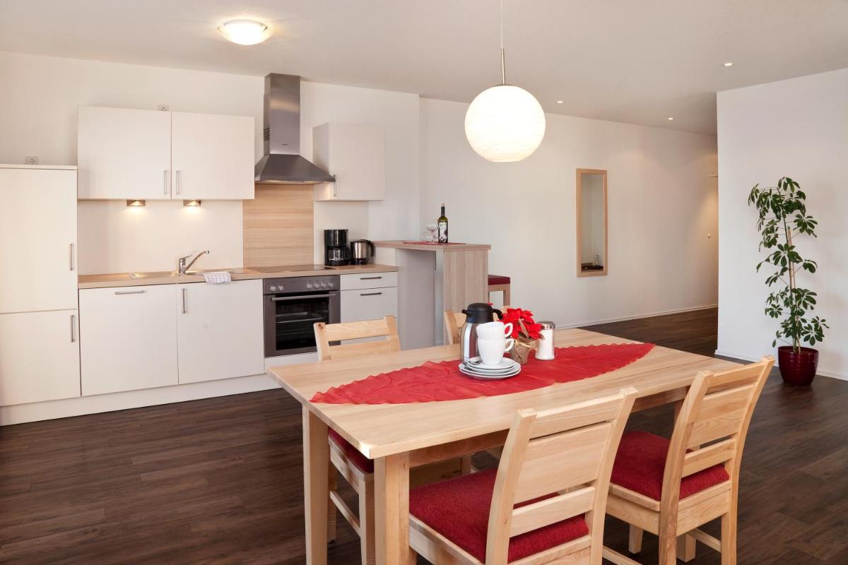 eine Küche und ein Esszimmer mit Tisch und Stühlen in der Unterkunft Seehotel und Appartements Schnöller in Rieden