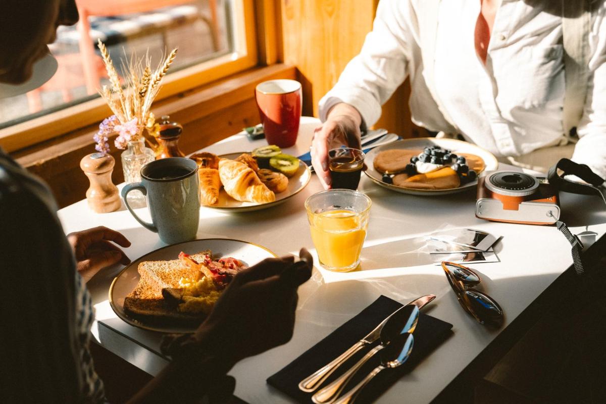 - un groupe de personnes assises à une table pour le petit-déjeuner dans l'établissement Big Sky Hotel & Spa, à Chamonix-Mont-Blanc