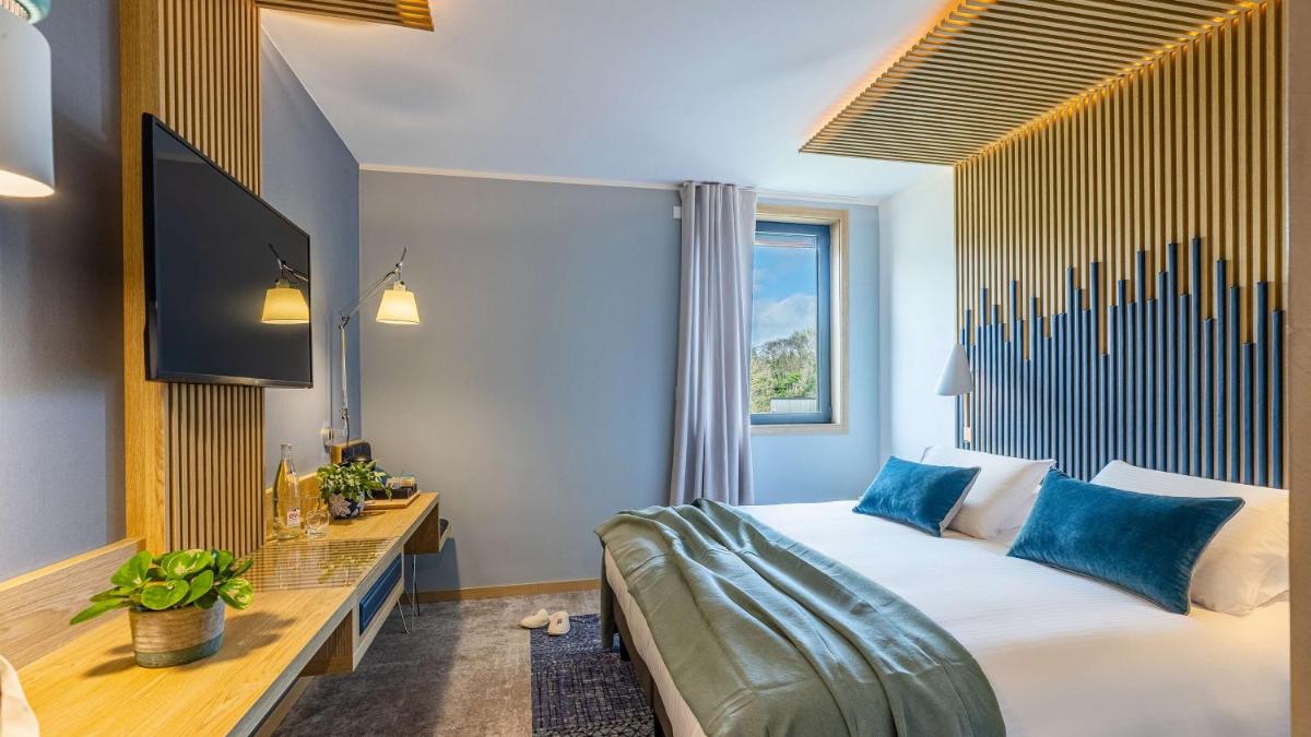 une chambre d'hôtel avec un lit et une télévision dans l'établissement Domaine de Dolomieu Hotel & Spa - BW Premier Collection, à Dolomieux 107 autres photos