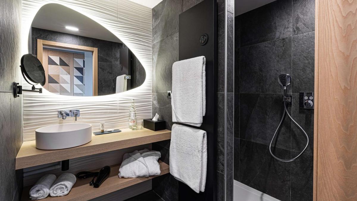 une salle de bains avec lavabo et douche avec miroir dans l'établissement Domaine de Dolomieu Hotel & Spa - BW Premier Collection, à Dolomieux