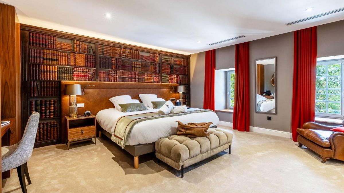 une chambre avec un grand lit et une chaise dans l'établissement Domaine de Dolomieu Hotel & Spa - BW Premier Collection, à Dolomieux