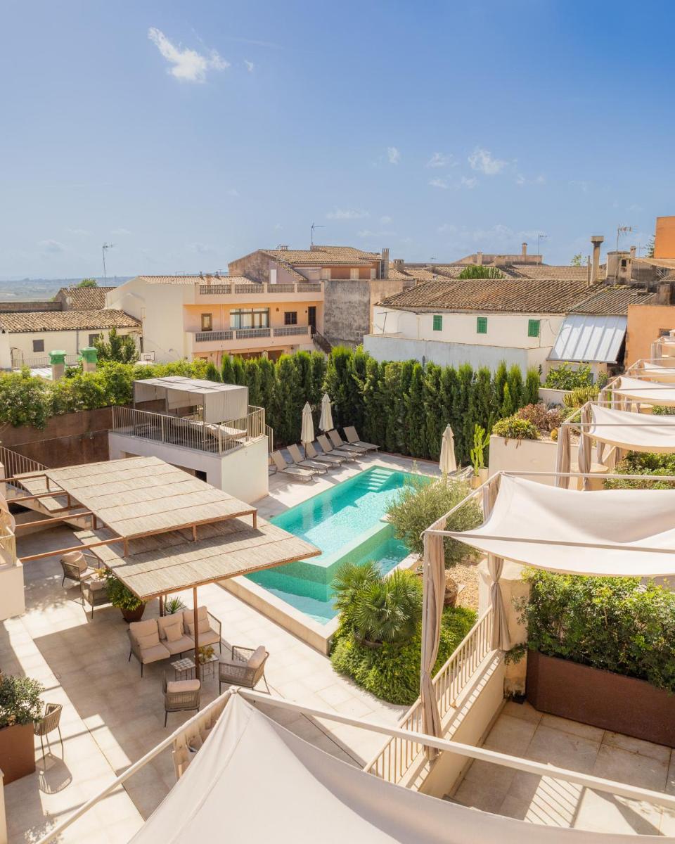un apartamento con piscina y sombrillas en Ynaira hotel & Spa, en Ariany
