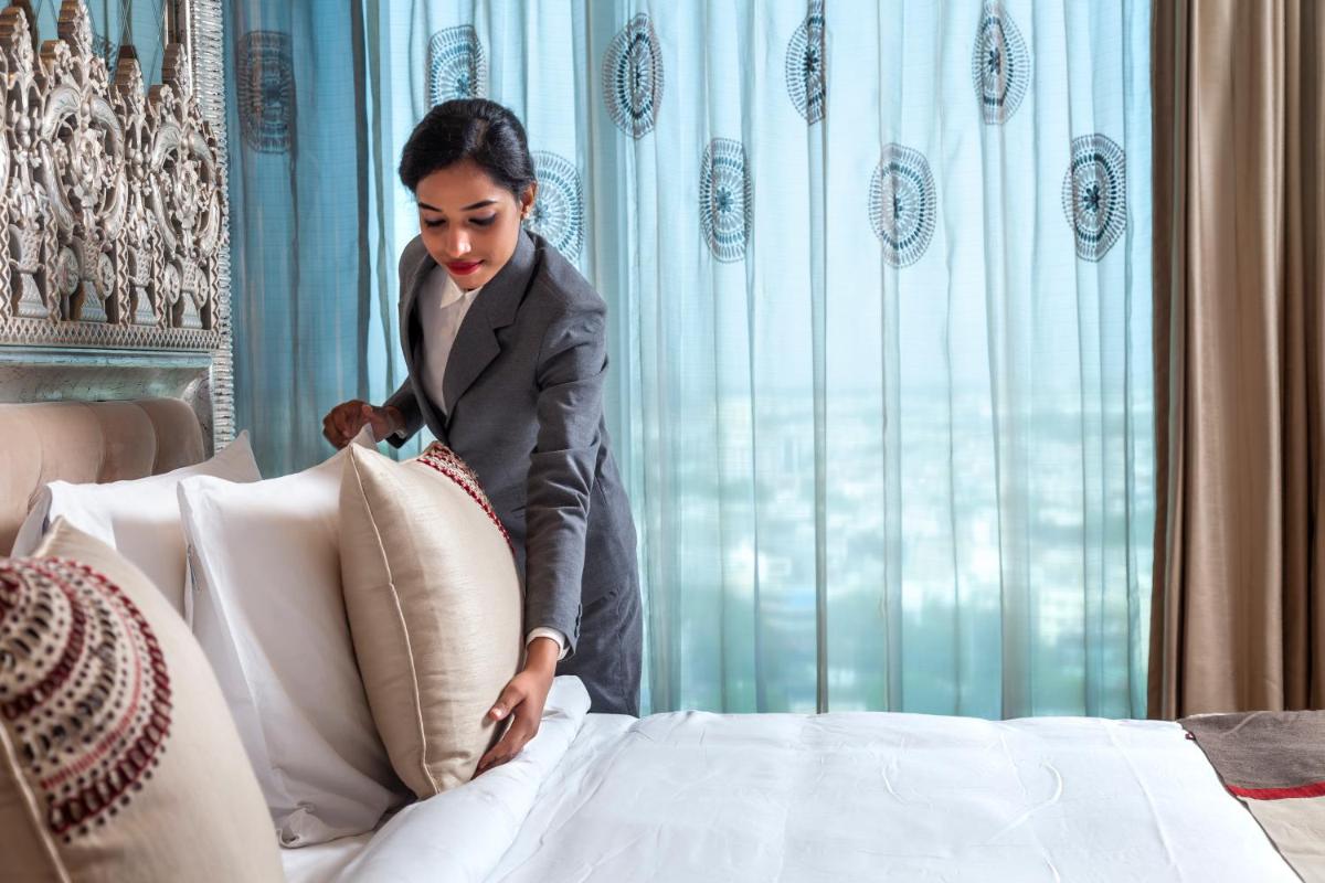 a woman leaning on a pillow on a bed at Seven Seas Hotel in New Delhi