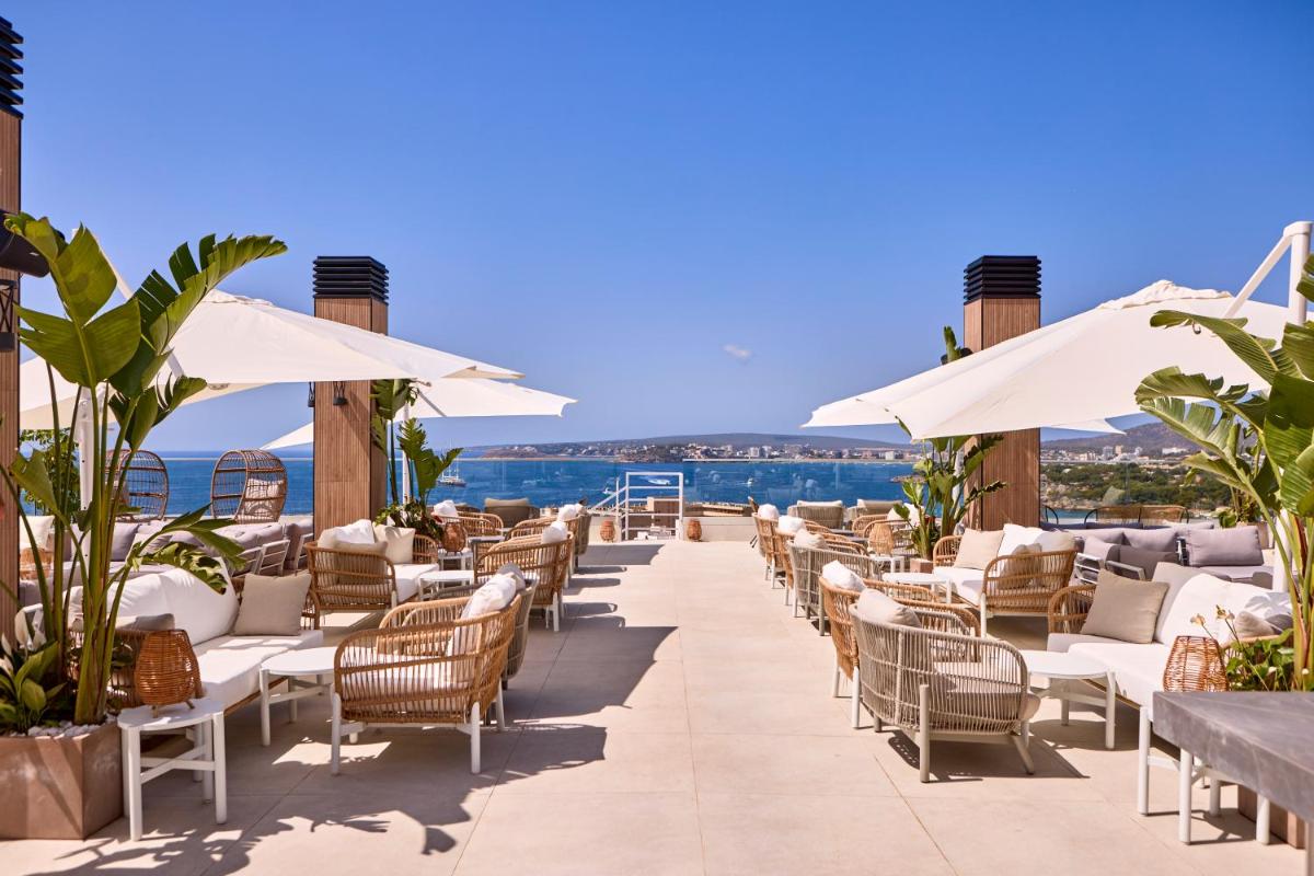 una fila de sillas y sombrillas en un complejo en Tomir Portals Suites - Adults Only, en Portals Nous