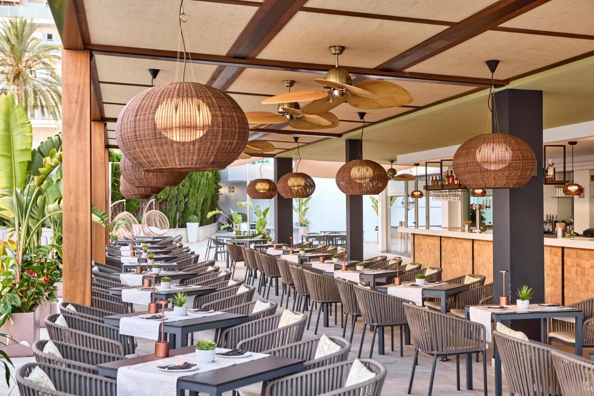 una fila de mesas y sillas en un restaurante en Tomir Portals Suites - Adults Only, en Portals Nous