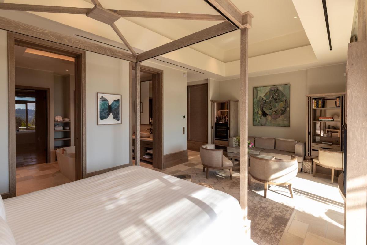 une chambre avec un lit et un salon dans l'établissement Coquillade Provence - Relais & Châteaux, à Gargas