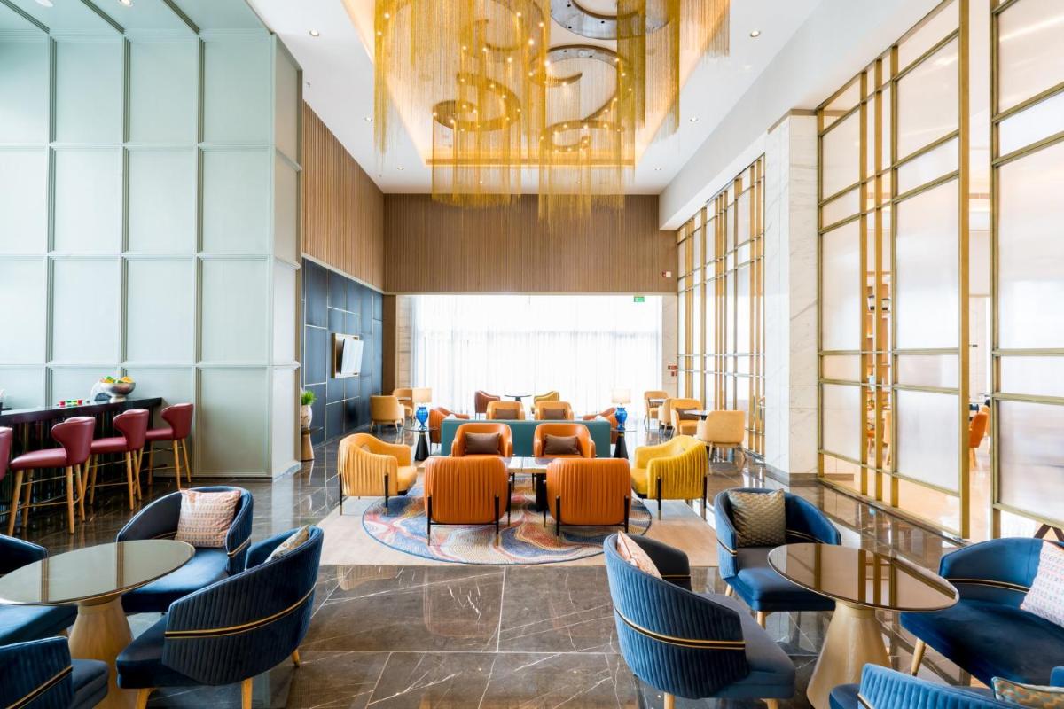a lobby of a restaurant with tables and chairs at Holiday Inn Lucknow Airport by IHG in Lucknow