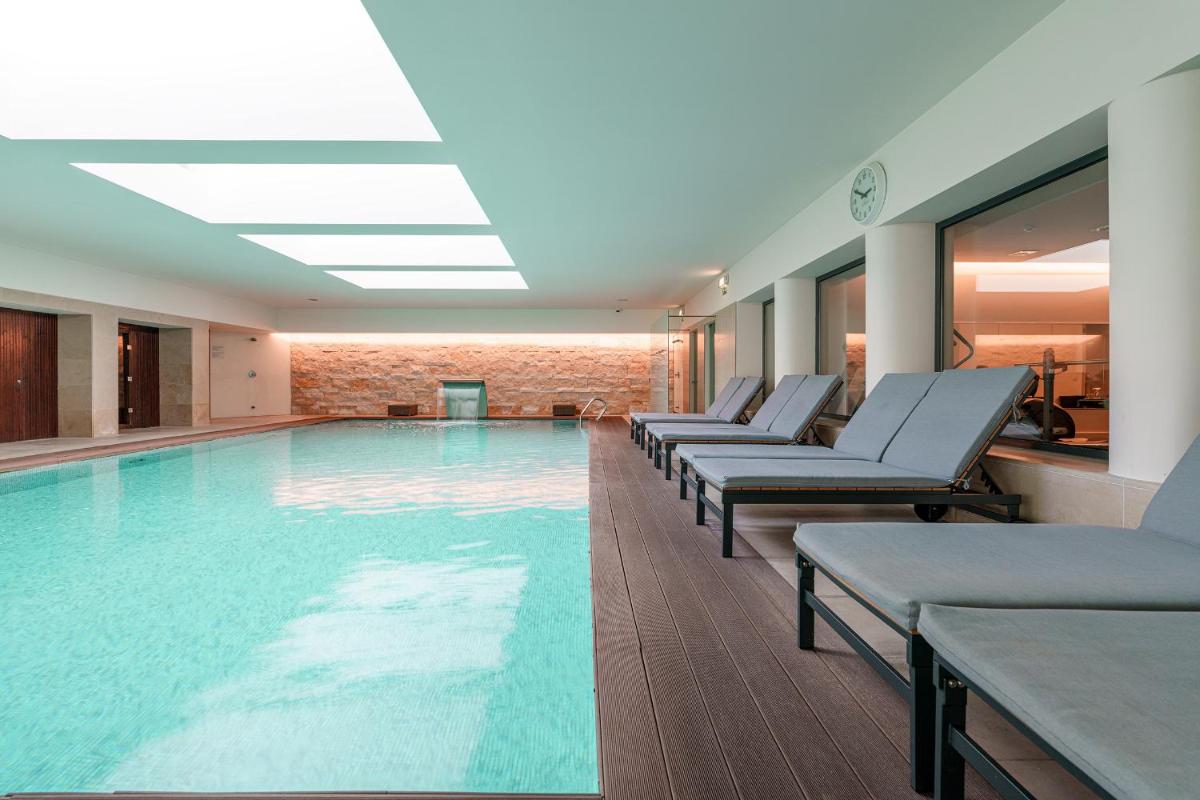 uma grande piscina com espreguiçadeiras em um prédio em Hotel Dom Goncalo & Spa em Fátima